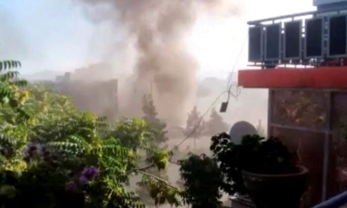 Smoke rises from a building near a Sikh temple following a blast in a car loaded with explosives in Kabul, Afghanistan, on June 18, 2022, in this still from video. (Social media video via Reuters)