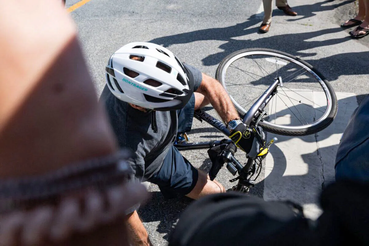 President Joe Biden falls off his bicycle following a bike ride in Rehoboth Beach, Delaware, on June 18, 2022. (Saul Loeb/AFP/Getty Images)