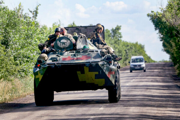Ukrainian troops ride on a military