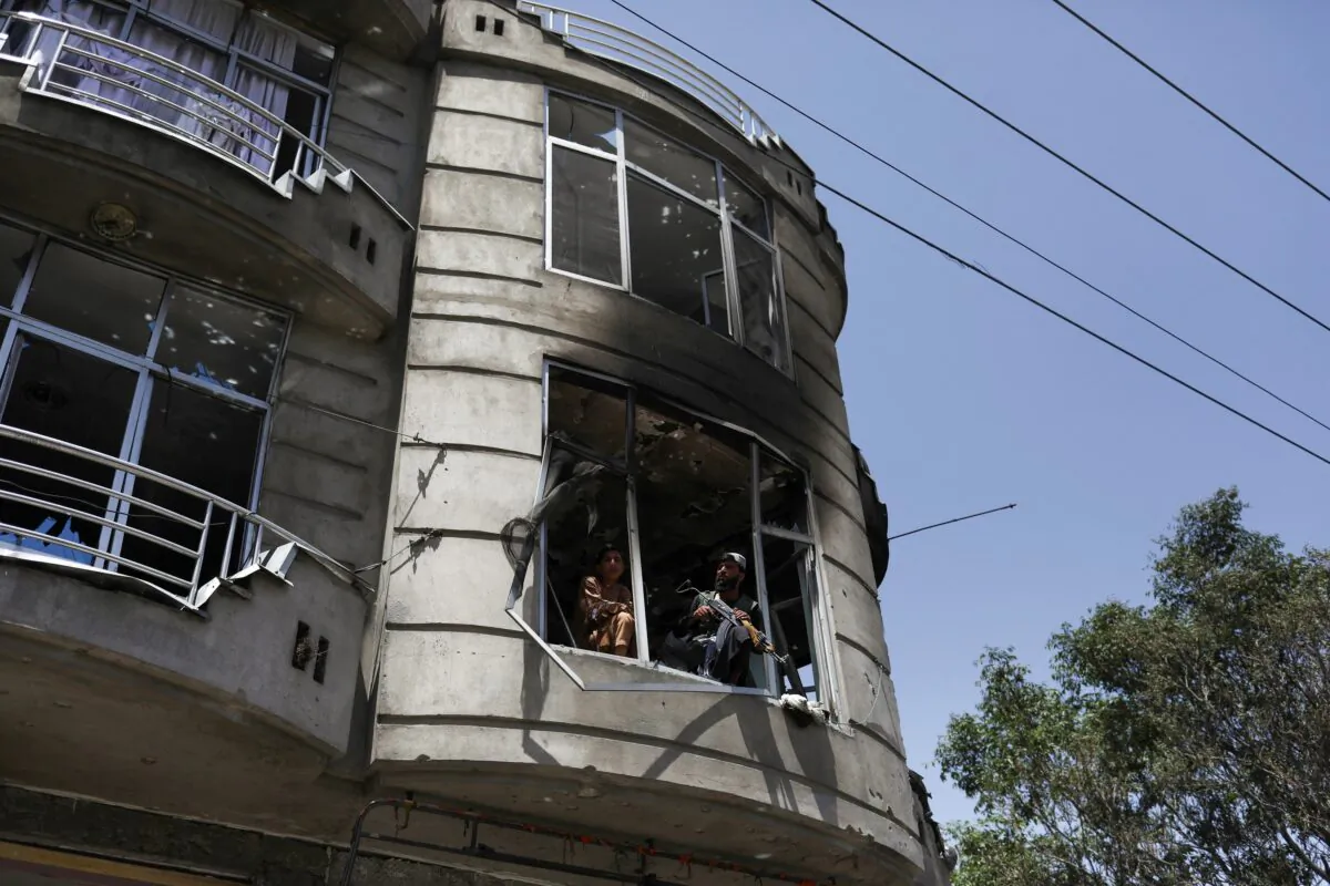 Taliban fighters stand guard at the site where an explosive-laden vehicle detonated amidst an attack on a Sikh Temple in Kabul, Afghanistan, on June 18, 2022. (Ali Khara/Reuters)
