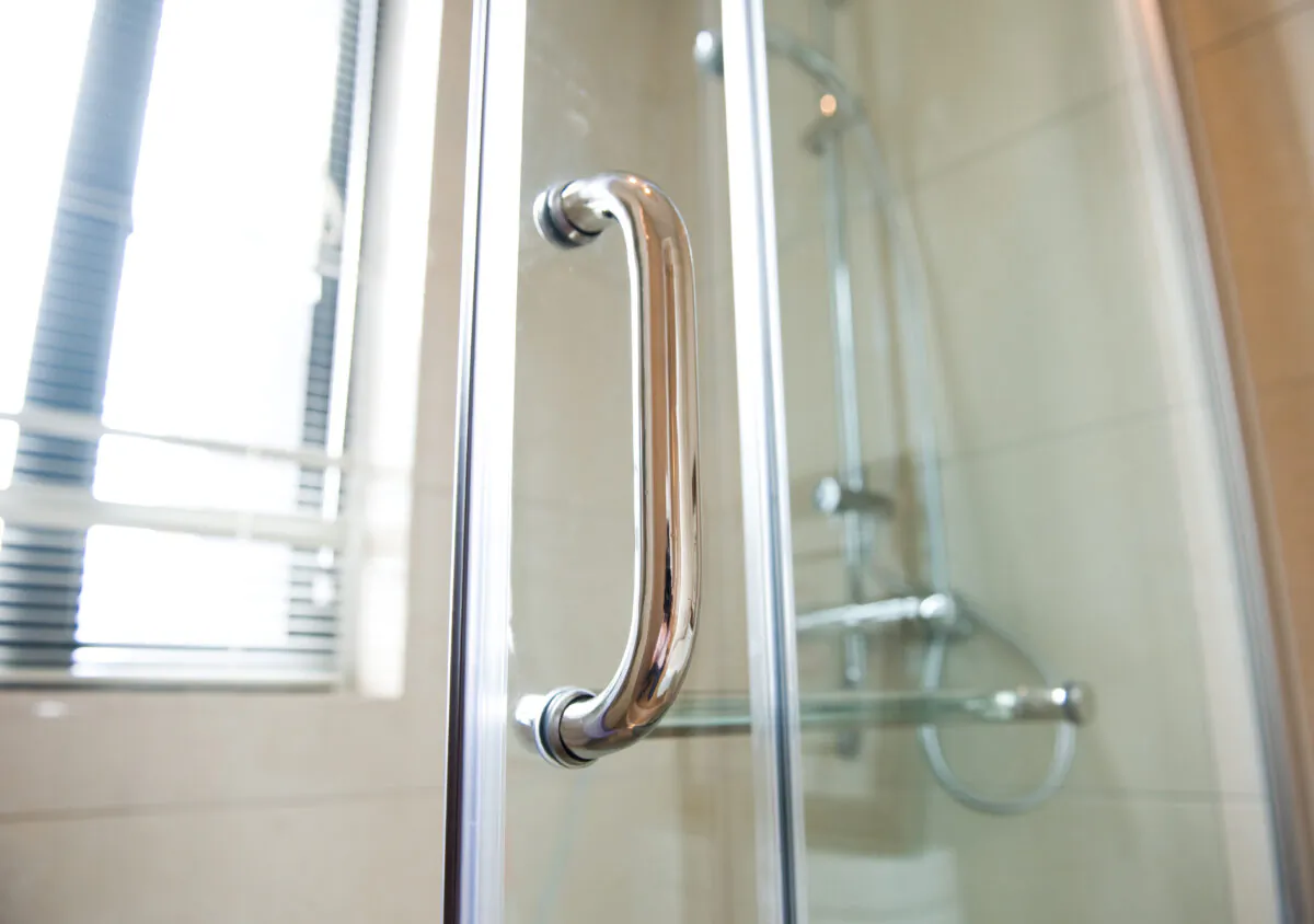 A hinged shower door instead of a curtain can be an attractive improvement that changes the feeling of the room.
 (hxdbzxy/Shutterstock)