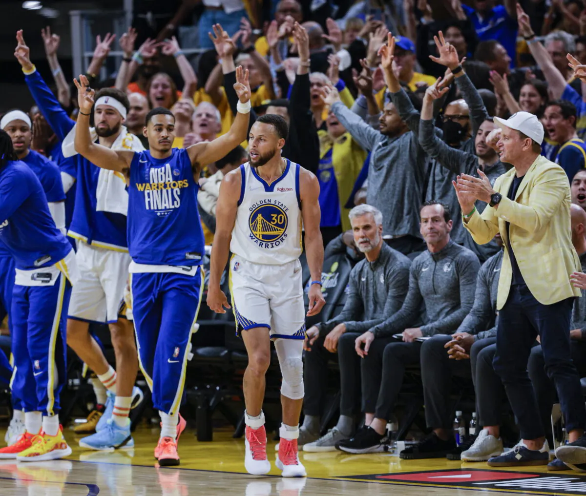Fans and the Golden State Warriors' bench reacts after Stephen Curry (30) hit a three point shot during the third quarter of Game 2 of basketball's NBA Finals against the Boston Celtics in San Francisco, on June 5, 2022. (Carlos Avila Gonzalez/San Francisco Chronicle via AP)
