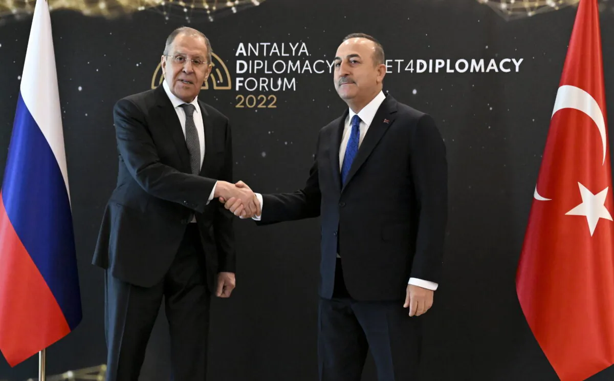 Turkish Foreign Minister Mevlut Cavusoglu (R) and Russia's Foreign Minister Sergey Lavrov shake hands during their meeting in Antalya, Turkey, on March 10, 2022. (Russian Foreign Ministry Press Service via AP)