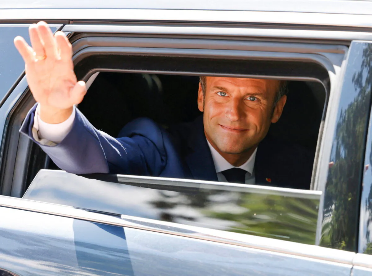 French President Emmanuel Macron waves as he votes in the first round of French parliamentary elections, at a polling station in Le Touquet, France, on June 12, 2022. (Ludovic Marin/Pool via Reuters)