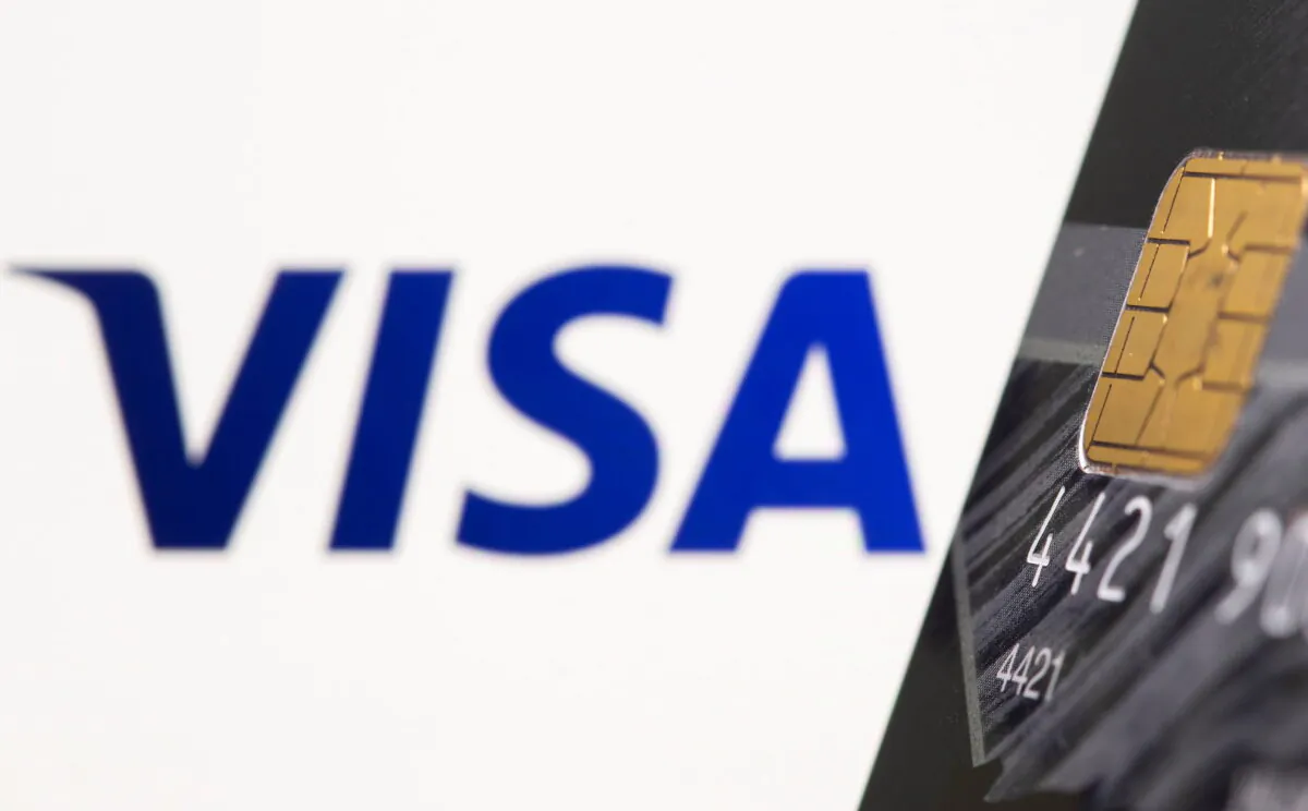 Credit card is seen in front of displayed Visa logo in this illustration taken on July 15, 2021. (Dado Ruvic/Reuters)