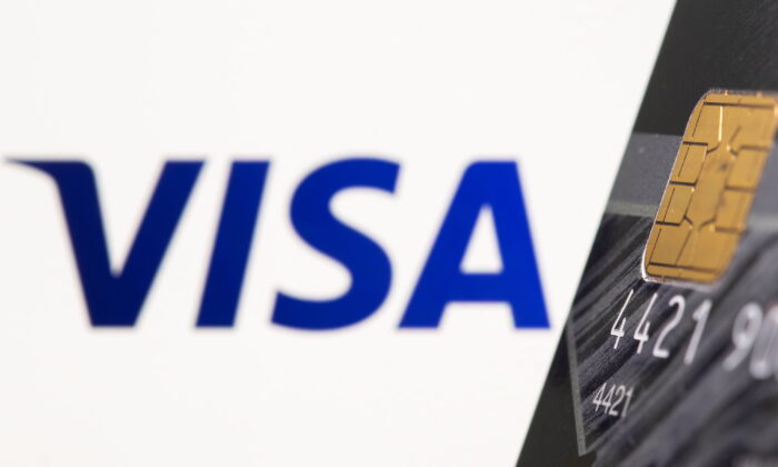 Credit card is seen in front of displayed Visa logo in this illustration taken on July 15, 2021. (Dado Ruvic/Reuters)