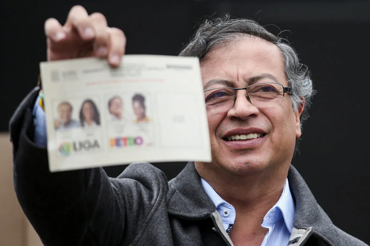 Colombian left-wing presidential candidate Gustavo Petro of the Historic Pact coalition shows his ballot before casting his vote at a polling station during the second round of the presidential election in Bogota, Colombia, on June 19, 2022. (Luisa Gonzalez/Reuters)