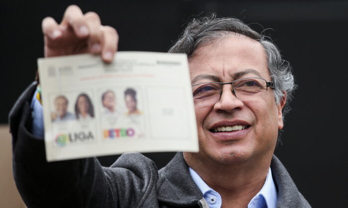 Colombian left-wing presidential candidate Gustavo Petro of the Historic Pact coalition shows his ballot before casting his vote at a polling station during the second round of the presidential election in Bogota, Colombia, on June 19, 2022. (Luisa Gonzalez/Reuters)