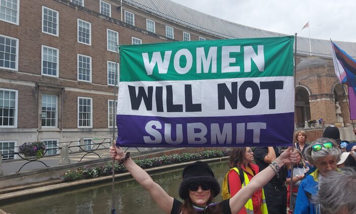A woman holding a "Women will not submit" banner in Bristol, England, on June 19, 2022. (Courtesy of Standing For Women)