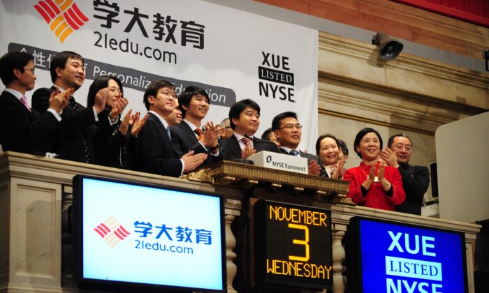 Officials of Xueda Education Group XUE, the leading national provider of tutoring services for primary and secondary school students in China, ring the opening bell while launching an Initial Public Offering (IPO) at the New York Stock Exchange, Nov. 3, 2010 in New York. (Emmanuel Dunand/AFP via Getty Images)