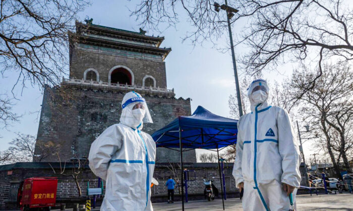 Health workers wear protective suits in Beijing on March 21, 2022. (Kevin Frayer/Getty Images)