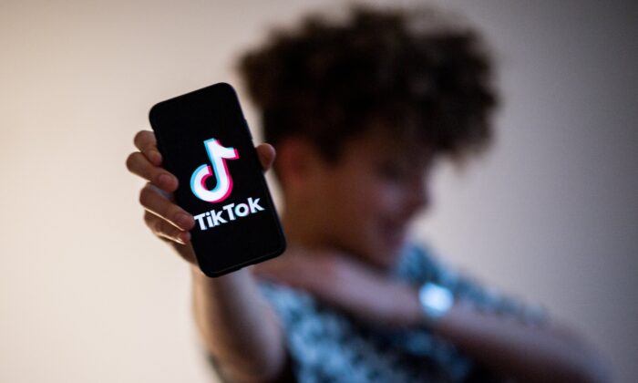 A teenager presents a smartphone with the logo of the Chinese social network TikTok on Jan. 21, 2021. (Loic Venance/AFP via Getty Images)