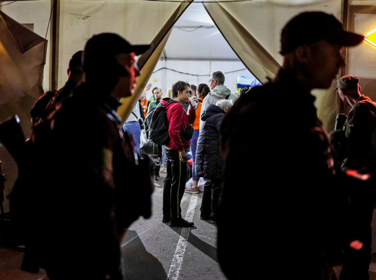Ukrainian refugees from the Azovstal steel plant in Mariupol arrive at a registration and humanitarian aid centre for internally displaced people as police guard in Zaporizhzhia, Ukraine, on May 8, 2022. (Gleb Garanich/Reuters)