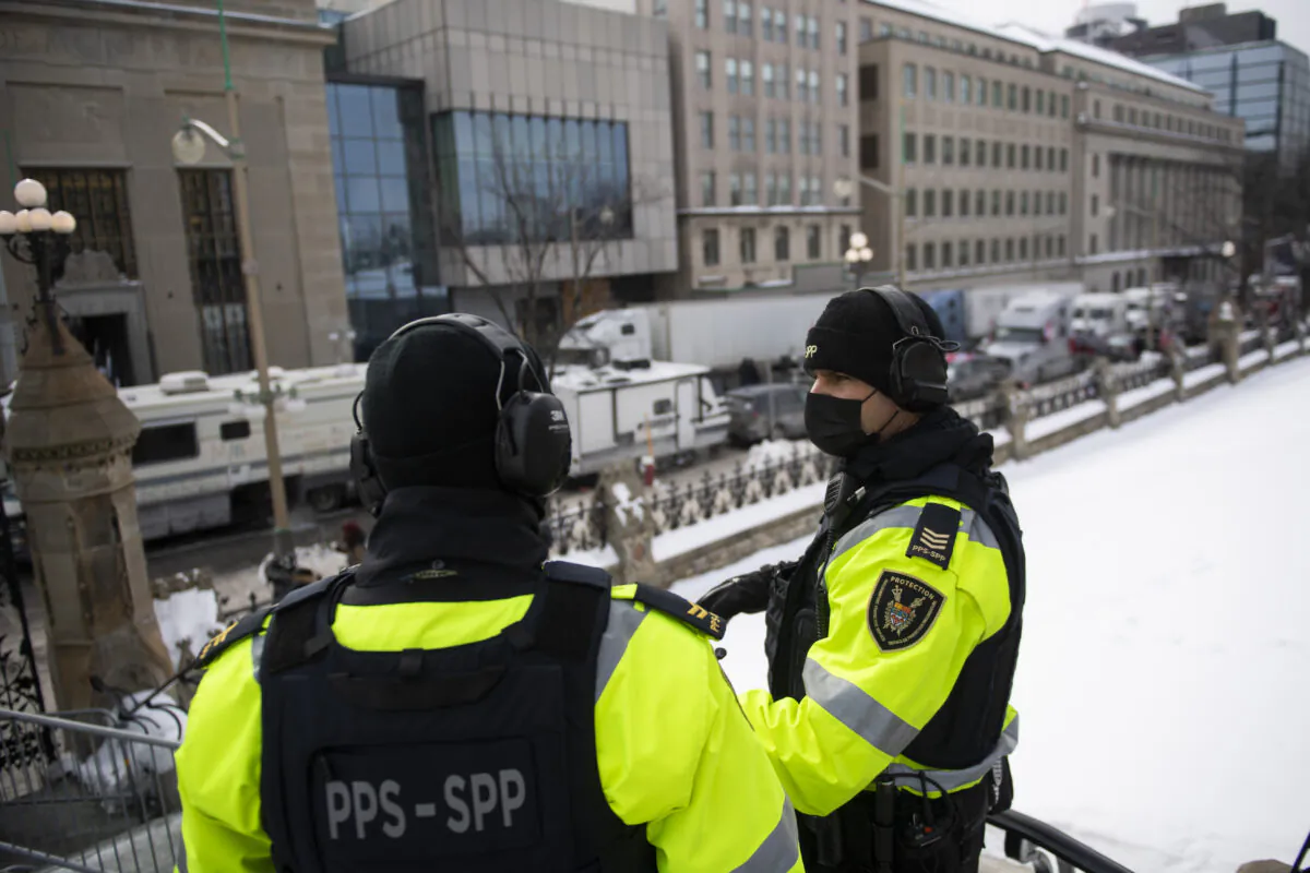 Parliamentary Protective Service officers wear headsets for hearing protection against the sound of truck horns during a rally against COVID-19 restrictions in Ottawa Jan. 31, 2022. (Justin Tang/The Canadian Press)