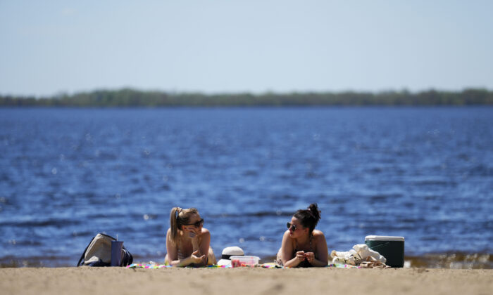 People enjoy Westboro Beach as temperatures hit 31C in Ottawa on May 13, 2022. (The Canadian Press/Sean Kilpatrick)