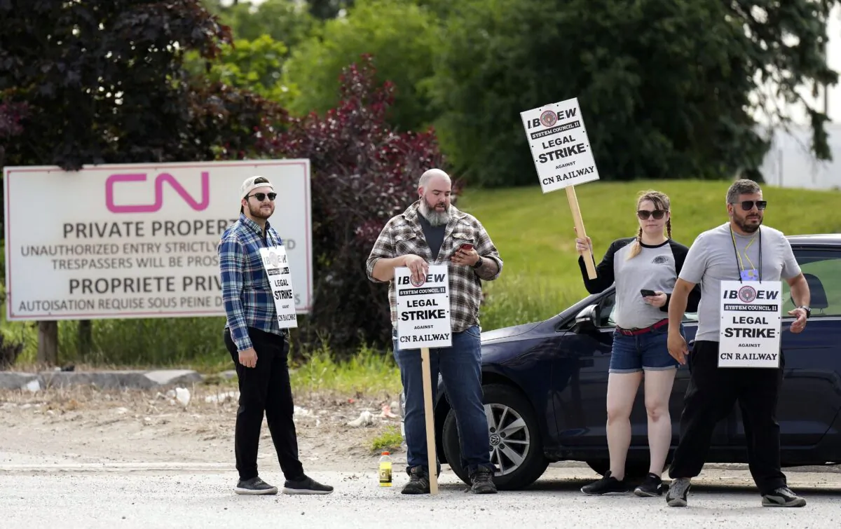 Striking CN rail workers at the CN MacMillan Yard in Vaughan, Ont., on June 20, 2022. The International Brotherhood of Electrical Workers says signal and communication workers have walked off the job across the country. (The Canadian Press/Nathan Denette)