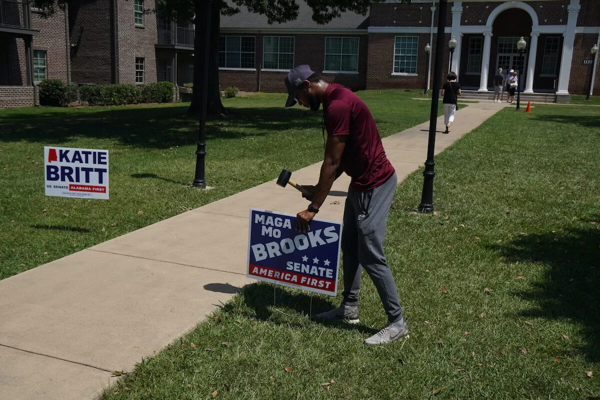 A supporter of Rep. Mo Brooks (R-Ala.) hammers a campaign sign into the ground outside a polling place at Huntingdon College in Montgomery, Alabama, on June 21, 2022 (Jackson Elliott/The Epoch Times)