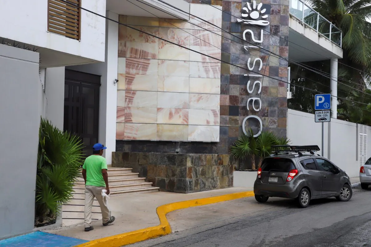 A man walks by Oasis 12 condo where two Canadian citizens, a man and a woman, were killed by unknown assailants, in Playa del Carmen, Mexico, on June 21, 2022. (Stringer/Reuters)