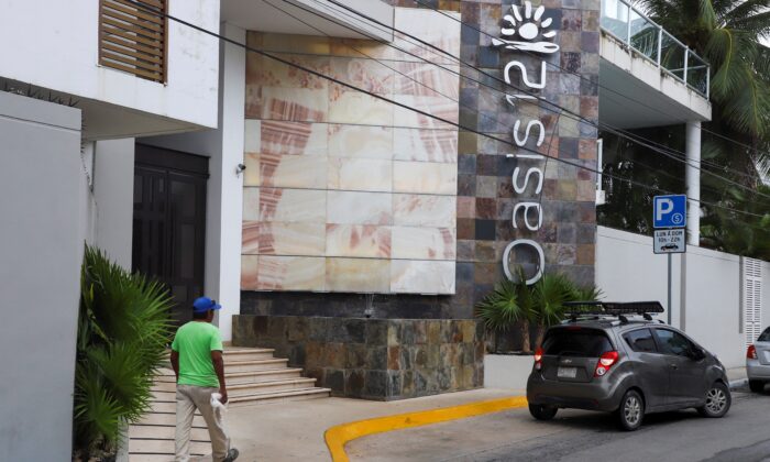 A man walks by Oasis 12 condo where two Canadian citizens, a man and a woman, were killed by unknown assailants, in Playa del Carmen, Mexico, on June 21, 2022. (Stringer/Reuters)