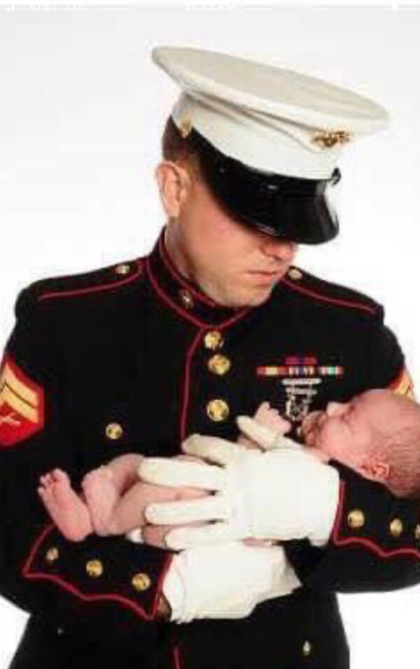 Marine veteran and January 6 prisoner Ryan Nichols holds his son.
