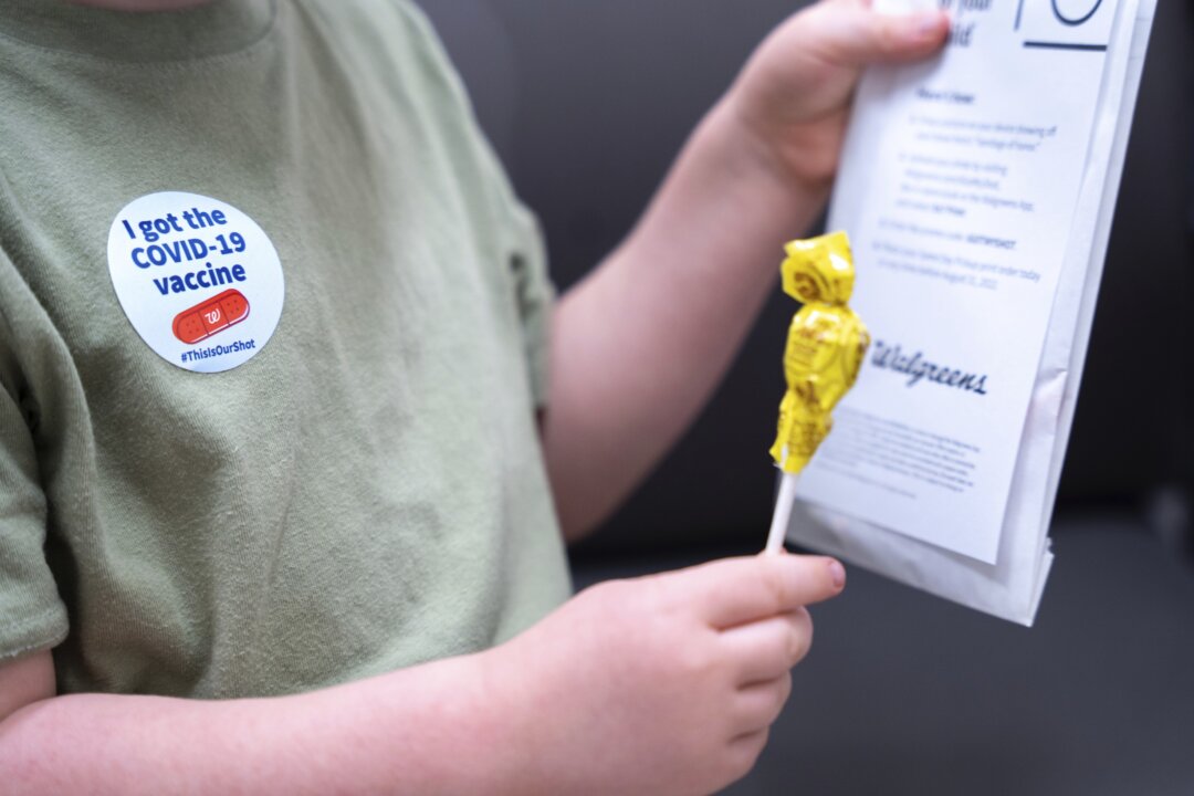 Fletcher Pack, 3, holds a lollipop after receiving the Moderna COVID-19 vaccination at a Walgreens pharmacy in Lexington, S.C., on June 20, 2022. (Sean Rayford/AP Photo)