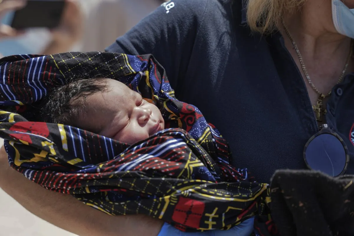 A paramedic holds a newborn boy at Mytilene port, on the northeastern Aegean Sea island of Lesbos, Greece, on June 22, 2022. (Panagiotis Balaskas/AP Photo)