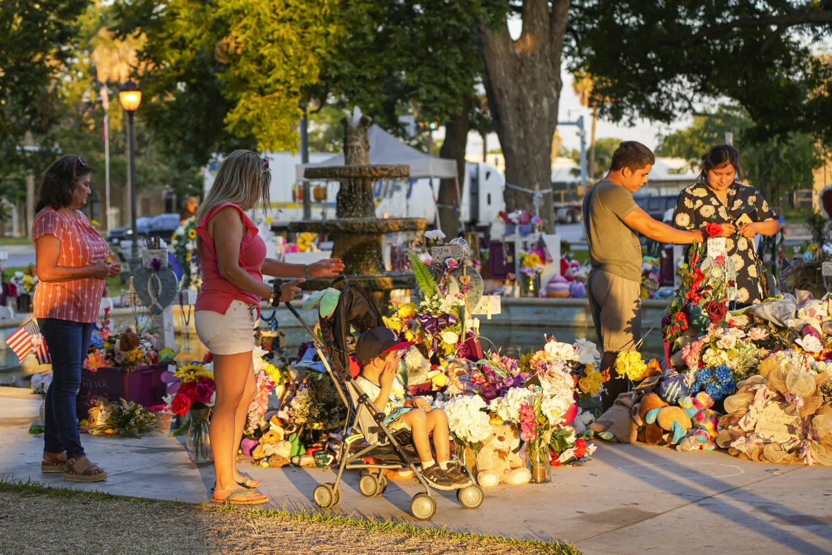 People visit a makeshift memorial for the 19 children and two teachers killed in the May 24 mass school shooting sits in the town square in Uvalde, Texas, on June 21, 2022. (Charlotte Cuthbertson/The Epoch Times)