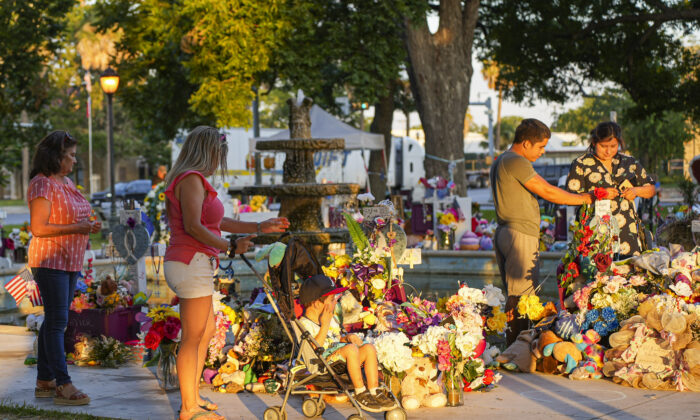 2022 年 6 月 21 日，在德克萨斯州乌瓦尔德的城镇广场，人们参观了 5 月 24 日大规模学校枪击案中遇难的 19 名儿童和两名教师的临时纪念碑。（夏洛特·卡斯伯森/时报）