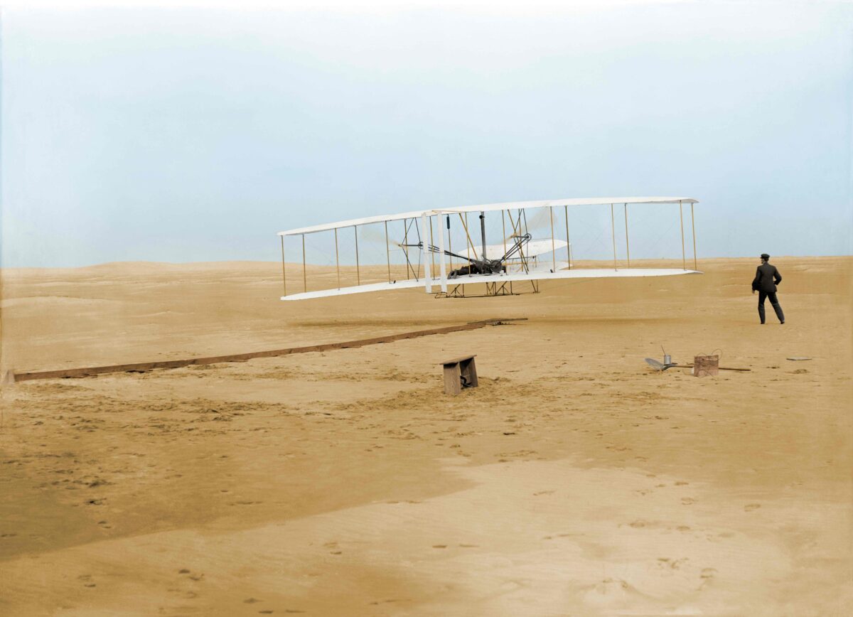 The first powered, controlled, and sustained flight was achieved in 1903 with Orville at the controls and Wilbur running alongside the plane to help maintain balance. (John T. Daniels)