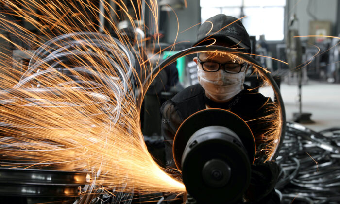 A worker polishes a bicycle steel rim at a factory manufacturing sports equipment in Hangzhou, Zhejiang province, China, on Sept. 2, 2019. (China Daily via Reuters)