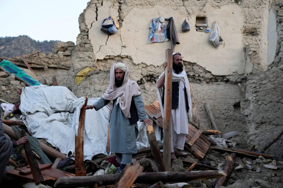 Afghans stand among destruction after an earthquake in Gayan village, in Paktika province, Afghanistan, on June 23, 2022. (Ebrahim Nooroozi/AP Photo)