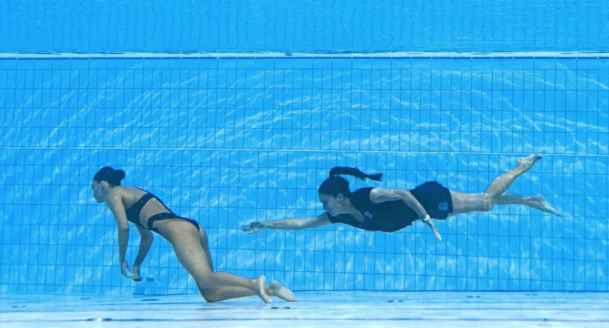 Coach Andrea Fuentes of Team USA (R) swims to recover USA's Anita Alvarez (L) from the bottom of the pool during an incident in the women's solo free artistic swimming finals, during the Budapest 2022 World Aquatics Championships at the Alfred Hajos Swimming Complex in Budapest on June 22, 2022. (Oli Scarff/AFP via Getty Images)