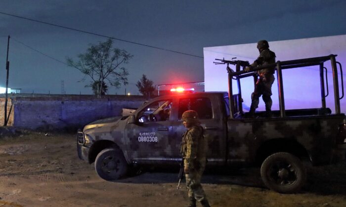 Members of the Mexican Army stand guard at the site where four police officers and eight alleged members of the organized crime were killed, and six others were wounded, in a confrontation in El Salto, Jalisco state, Mexico, on June 23, 2022. (Ulises Ruiz/AFP via Getty Images)