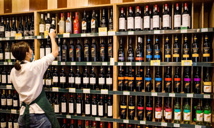 An employee works as Australian-made wine (on display shelves on R) are seen for sale at a store in Beijing on August 18, 2020. - China on August 18 ramped up tensions with Australia after it launched a probe into wine imports from the country, the latest salvo in an increasingly bitter row between the trade partners. (Photo by NOEL CELIS / AFP) (Photo by NOEL CELIS/AFP via Getty Images)