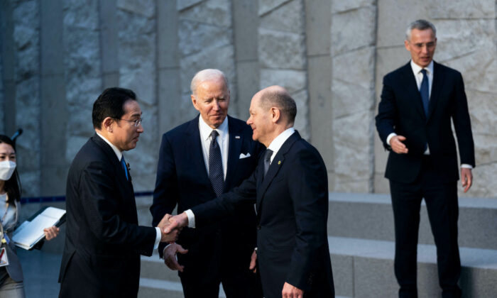 U.S. President Joe Biden and NATO Secretary General Jens Stoltenberg (R) look on as Germany's Chancellor Olaf Scholz (2R) shakes hands with Japan's Prime Minister Fumio Kishida (2L) during a photograph with G-7 Leaders at NATO Headquarters in Brussels on March 24, 2022. (Doug Mills/AFP via Getty Images)