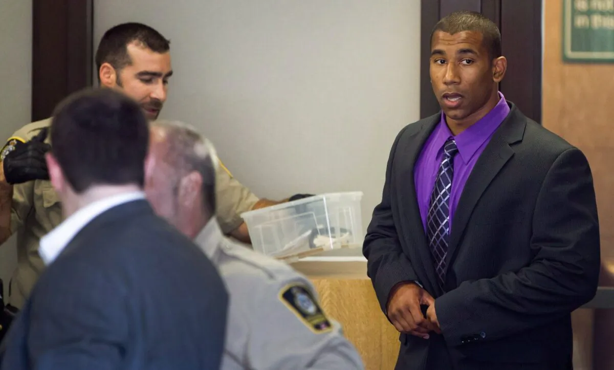 Former Canadian Football League wide receiver Joshua Boden, right, goes through security screening as he arrives at British Columbia Provincial Court in Vancouver, B.C., on July 26, 2012. (The Canadian Press/Darryl Dyck)