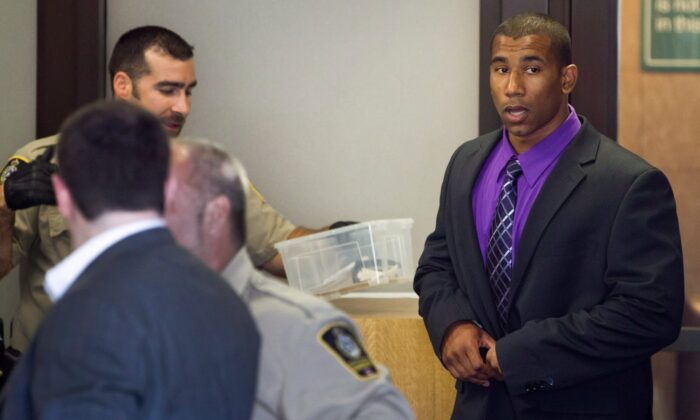 Former Canadian Football League wide receiver Joshua Boden, right, goes through security screening as he arrives at British Columbia Provincial Court in Vancouver, B.C., on July 26, 2012. (The Canadian Press/Darryl Dyck)