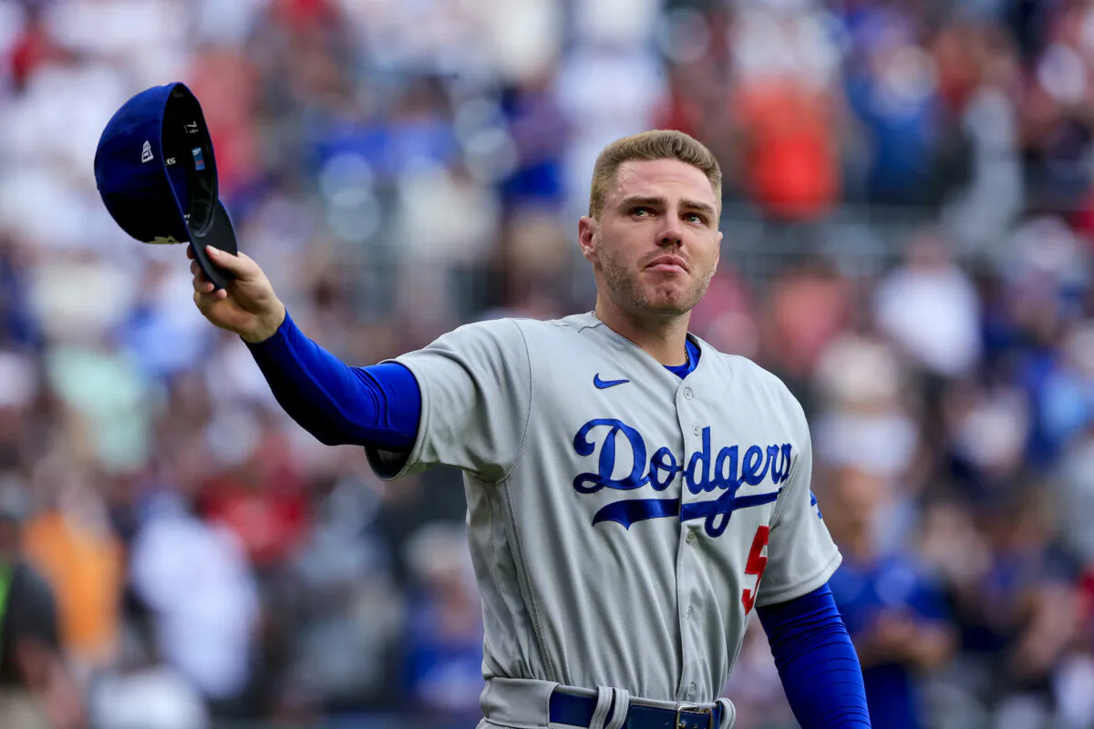 Los Angeles Dodgers first baseman Freddie Freeman walks to the field for the presentation of his World Series championship ring, before the team's baseball game against the Atlanta Braves, in Atlanta, on Friday, June 24, 2022. (AP Photo/Butch Dill)