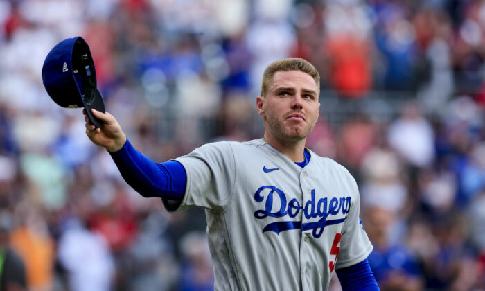Los Angeles Dodgers first baseman Freddie Freeman walks to the field for the presentation of his World Series championship ring, before the team's baseball game against the Atlanta Braves, in Atlanta, on Friday, June 24, 2022. (AP Photo/Butch Dill)