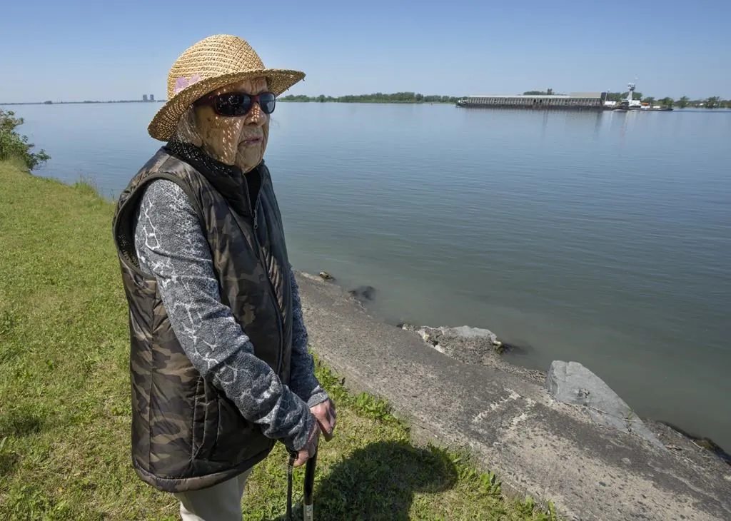 Angelique Beauchemin looks at the erosion on her property on the shore of the St. Lawrence River, in Vercheres, Que., on June 20, 2022. (The Canadian Press/Ryan Remiorz)