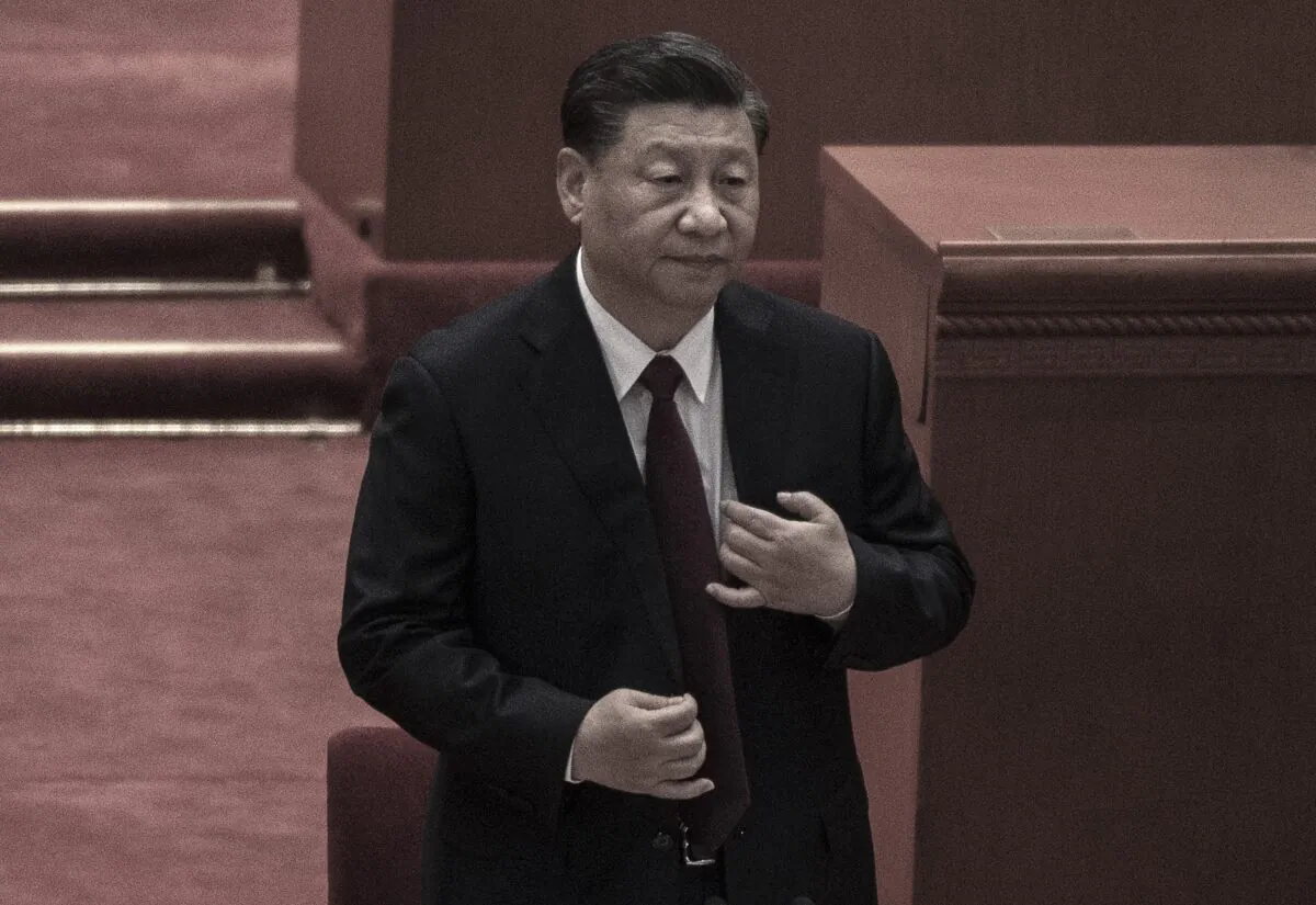 Chinese leader Xi Jinping buttons his jacket at a ceremony to honor contributions to the Beijing 2022 Winter Olympics and Paralympics in Beijing, China on April 8, 2022. (Kevin Frayer/Getty Images)