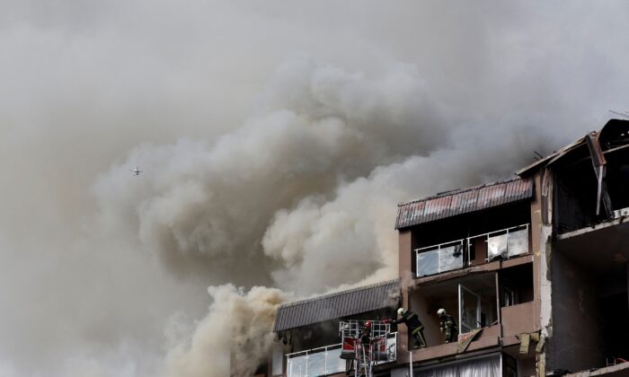 Firefighters work to put out a fire as smoke rises from residential building damaged by a Russian missile strike in Kyiv, Ukraine on June 26, 2022, as Russia's attack on Ukraine continues. (Valentyn Ogirenko/Reuters)