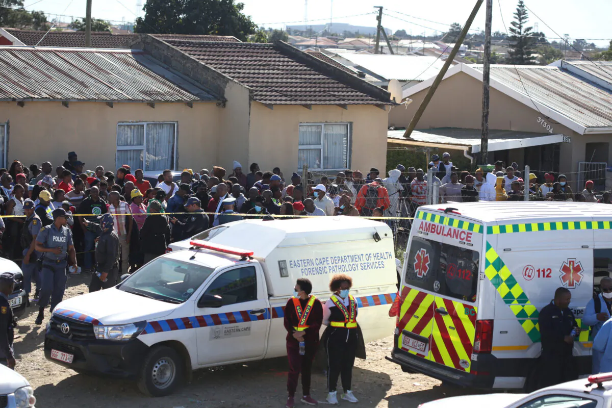 Crowd gathers as forensic personnel investigate after the deaths of patrons found inside the Enyobeni Tavern, in Scenery Park, outside East London in the Eastern Cape province, South Africa, on June 26, 2022. (Stringer/Reuters)