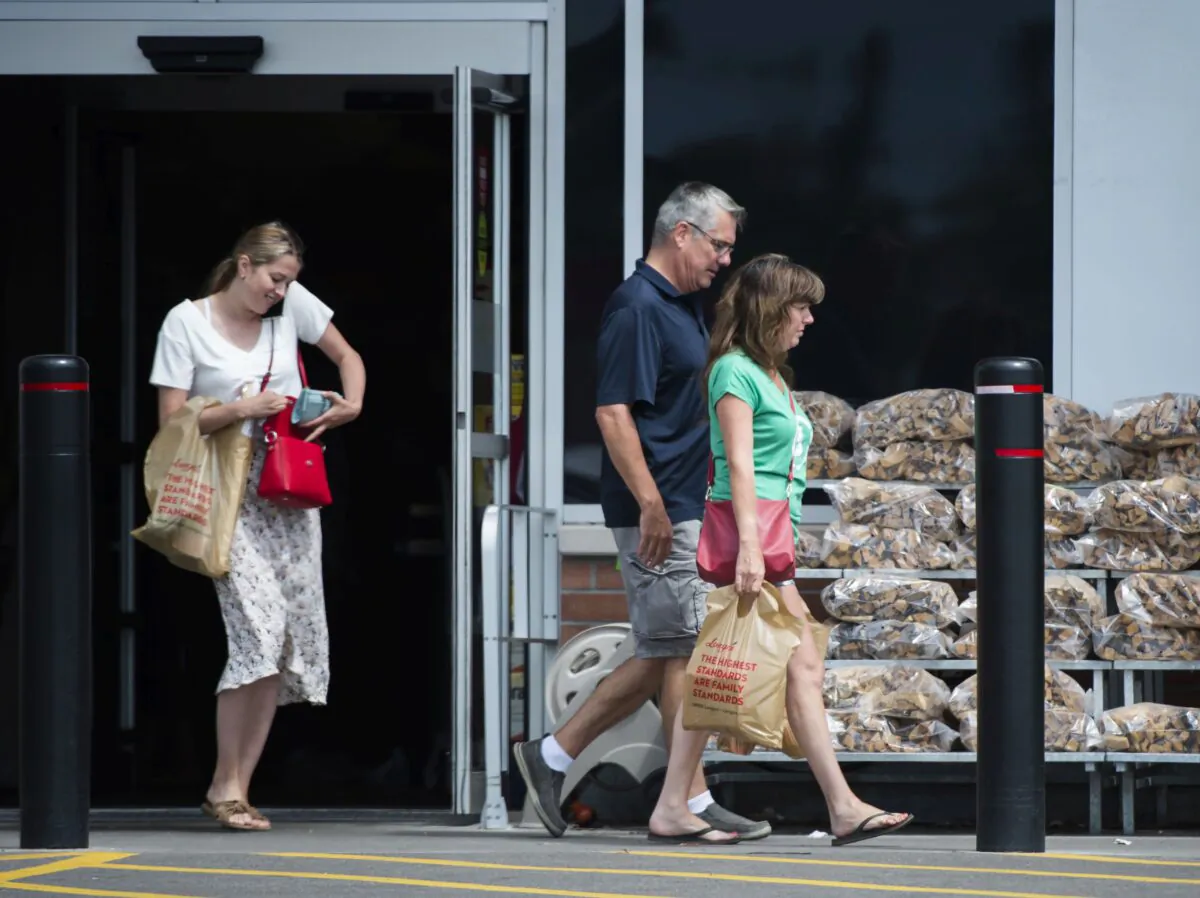People carrying plastic bags leave a grocery store in Mississauga, Ont., on Aug. 15, 2019. (The Canadian Press/Nathan Denette)