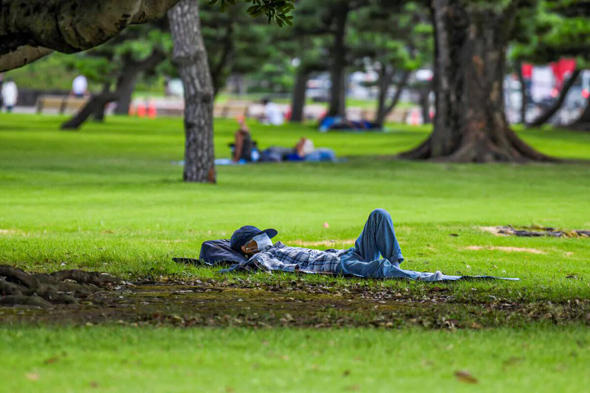 A man takes a nap in a park around the Imperial Palace during a heatwave in Tokyo on July 26, 2021. (Kazuhiro Nogi/AFP via Getty Images)