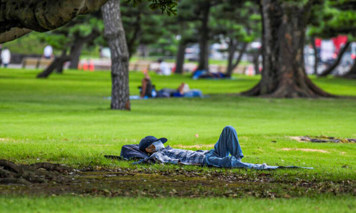 A man takes a nap in a park around the Imperial Palace during a heatwave in Tokyo on July 26, 2021. (Kazuhiro Nogi/AFP via Getty Images)