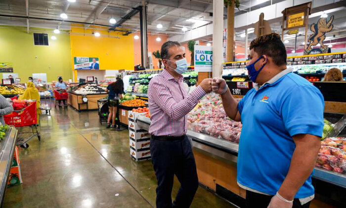Sean Loloee (L), a candidate for Sacramento City Council District 2, fist bumps produce manager Miguel Vaca at Viva Supermarket in Sacramento's Del Paso Heights neighborhood on Nov. 4, 2020. (Paul Kitagaki Jr./The Sacramento Bee/TNS)