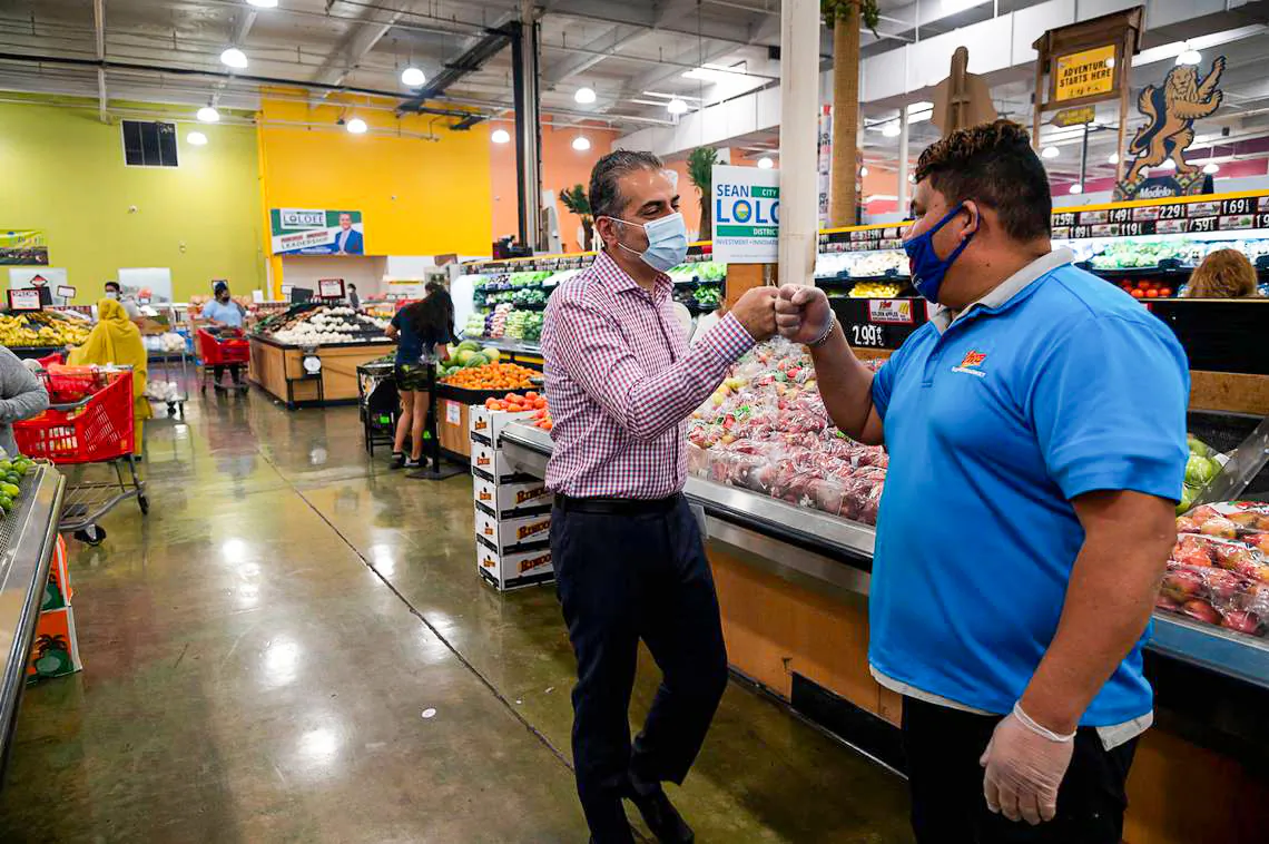 Sean Loloee (L), a candidate for Sacramento City Council District 2, fist bumps produce manager Miguel Vaca at Viva Supermarket in Sacramento's Del Paso Heights neighborhood on Nov. 4, 2020. (Paul Kitagaki Jr./The Sacramento Bee/TNS)