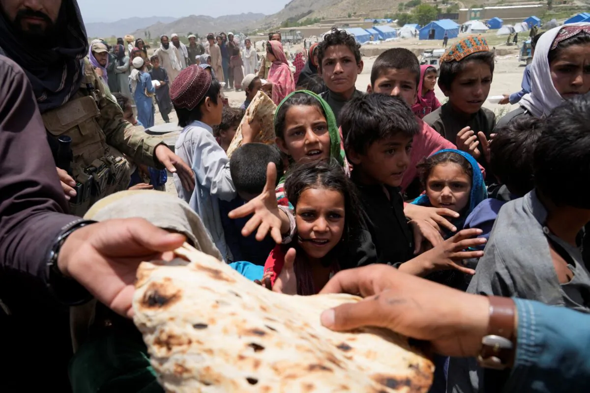 Afghans receive aid at a camp after an earthquake in Gayan district in Paktika Province, Afghanistan, on June 26, 2022. (Ebrahim Nooroozi/AP Photo)
