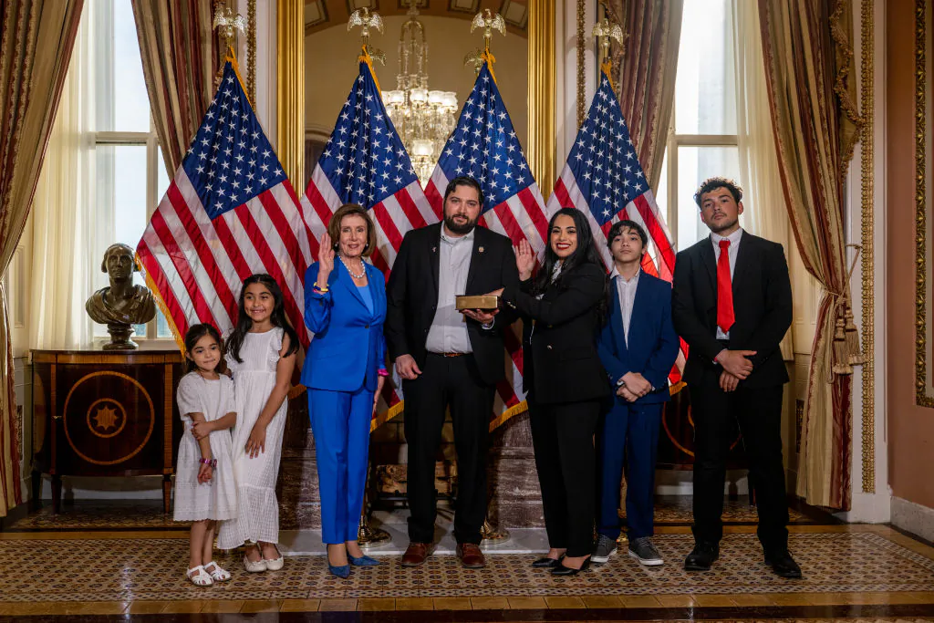 Rep. Mayra Flores (R-Texas) stands with her family and Speaker of the House Nancy Pelosi (D-Cali.) for a portrait after being sworn-in on June 21, 2022, in Washington. (Brandon Bell/Getty Images)